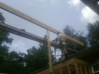 Carpenter setting a ridge beam over a new addition frame — Ice Dam Removal by Roofing Brothers in Hasbrouck Heights