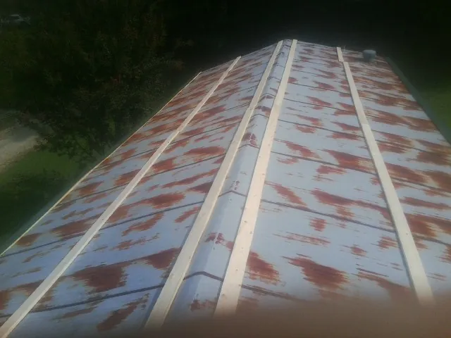 Rusted metal roof panels with new wood purlins before replacement — Storm Damage Roof Repair in Hasbrouck Heights by Roofing Brothers
