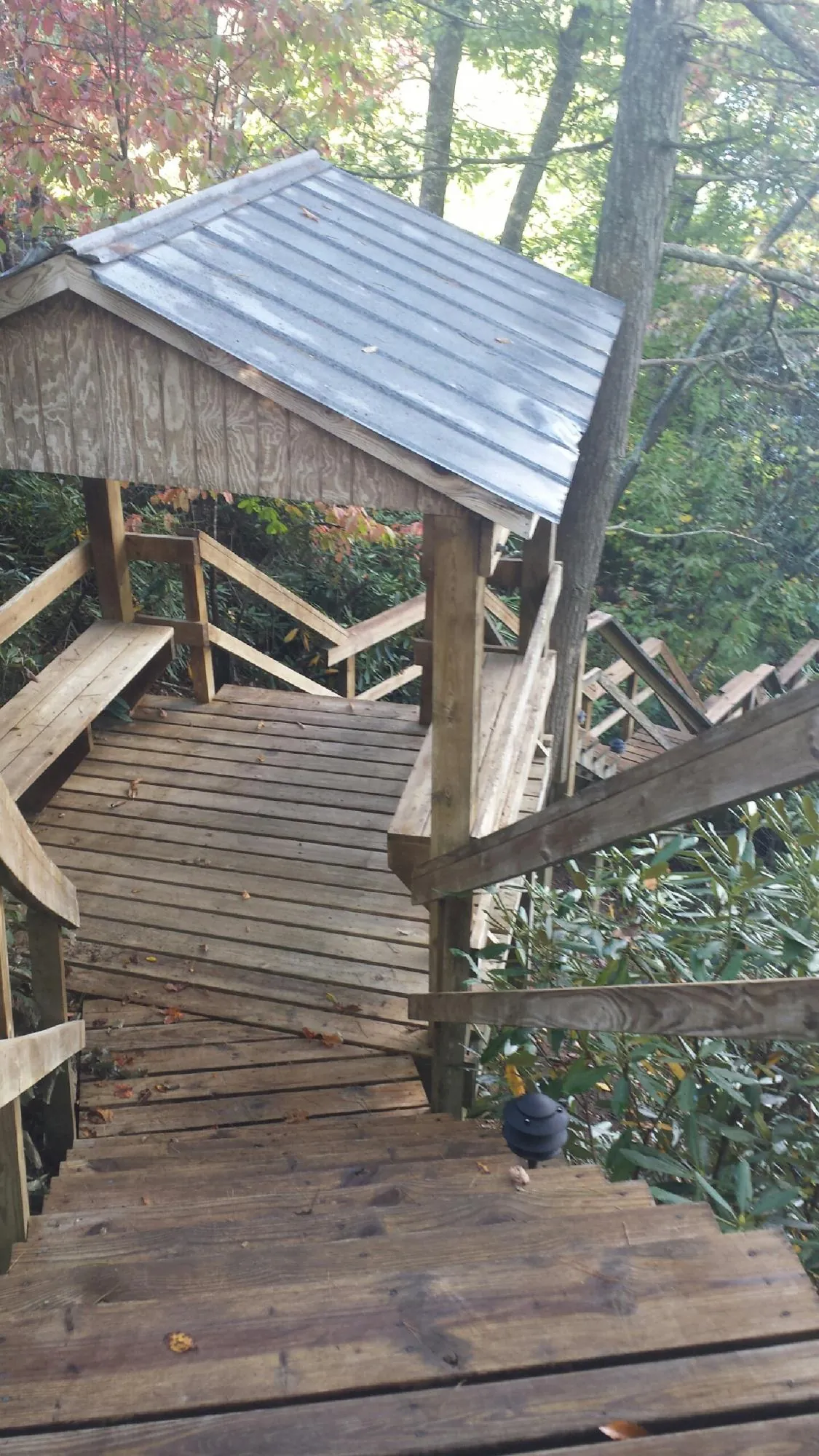 Metal roofed shelter over wooden steps on a wooded walkway — Skylight Repair & Installation work by our crew in Hasbrouck Heights