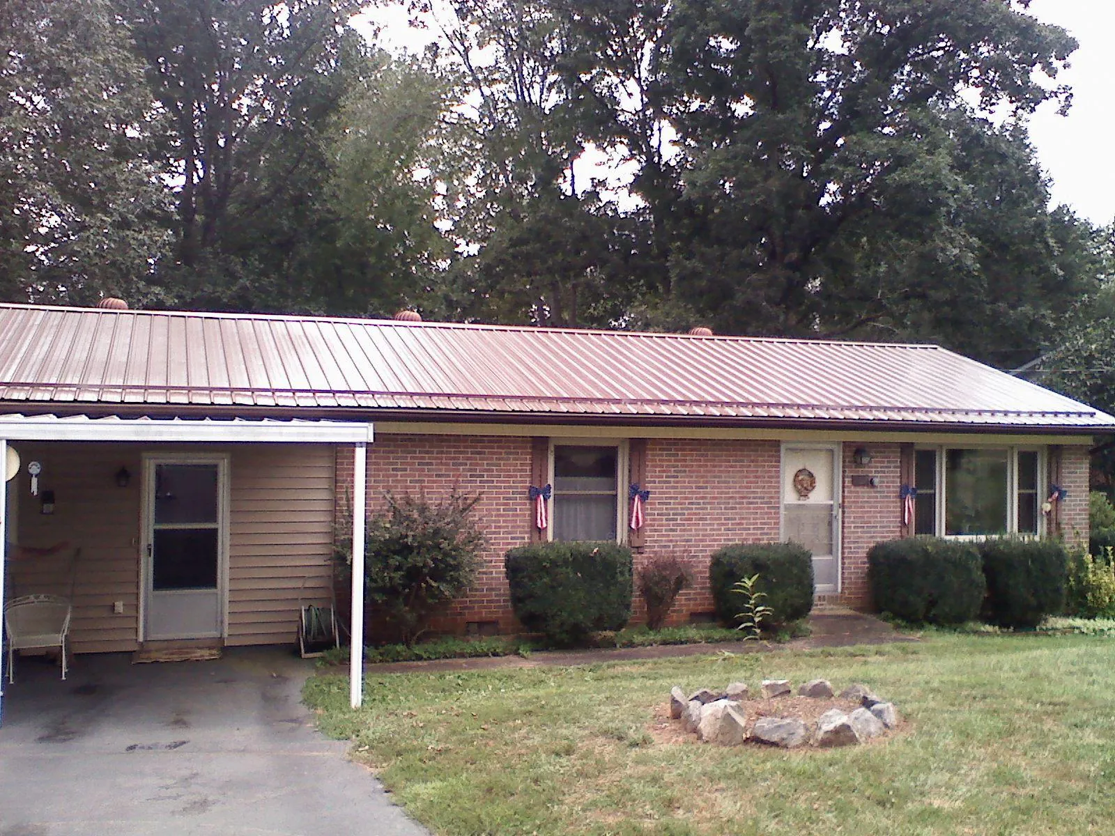 Bronze metal roof and carport on a brick ranch home — Roof Repair work by our crew in Hasbrouck Heights
