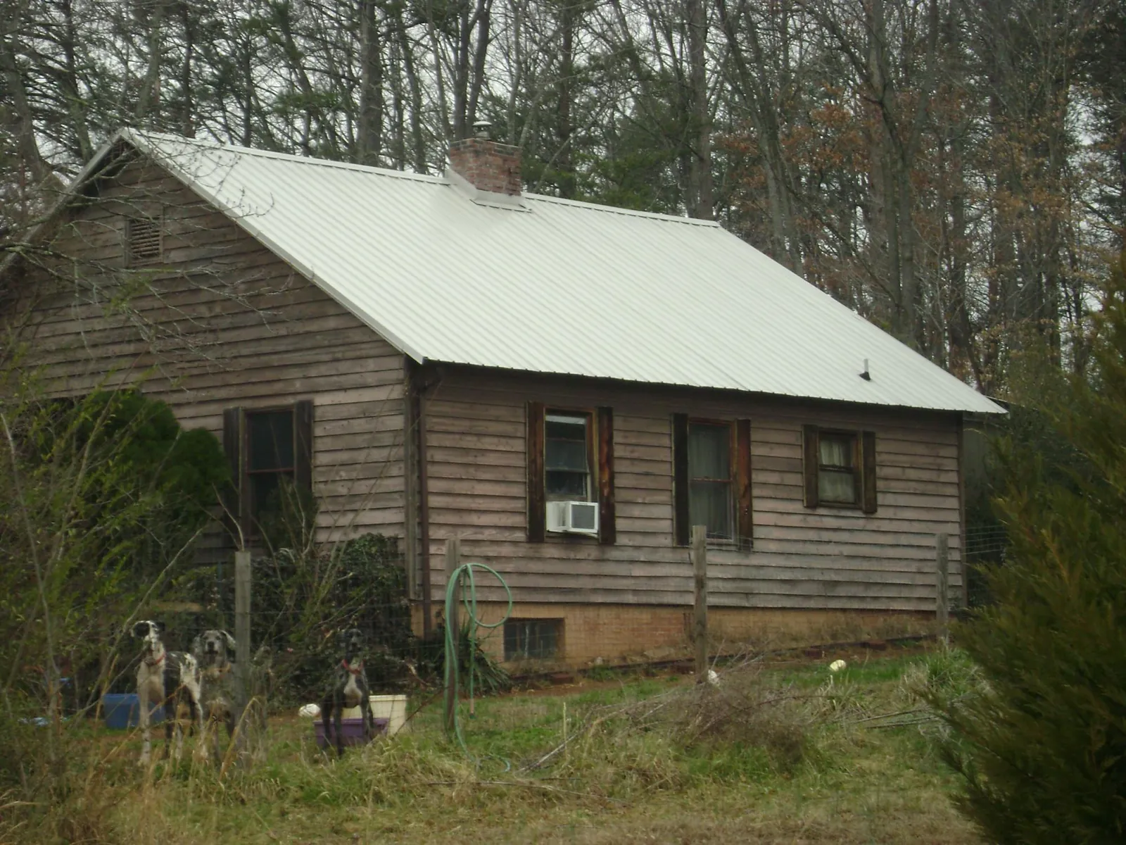 White metal roof on an old wood sided farmhouse, from a Metal Roof Installation job in Hasbrouck Heights